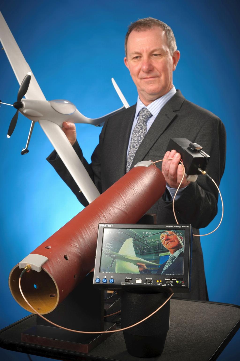 Paul Burling holds a composite tube through which a video is being transmitted using SurFlow electronics